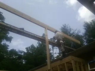 Carpenter setting a ridge beam over a new addition frame — Ice Dam Removal by Roofing Brothers in Waupaca