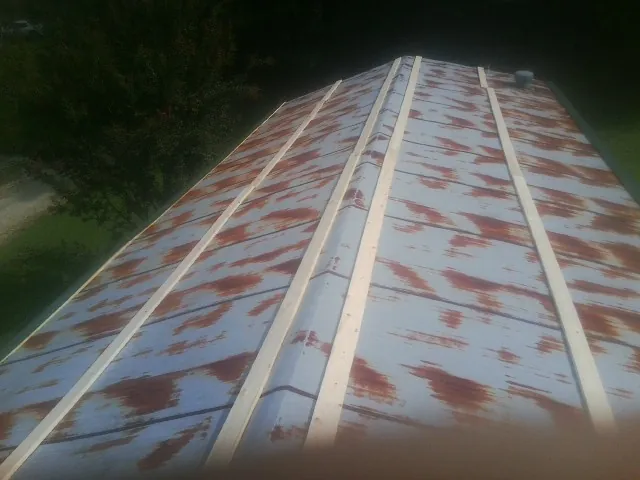 Rusted metal roof panels with new wood purlins before replacement — Storm Damage Roof Repair in Waupaca by Roofing Brothers