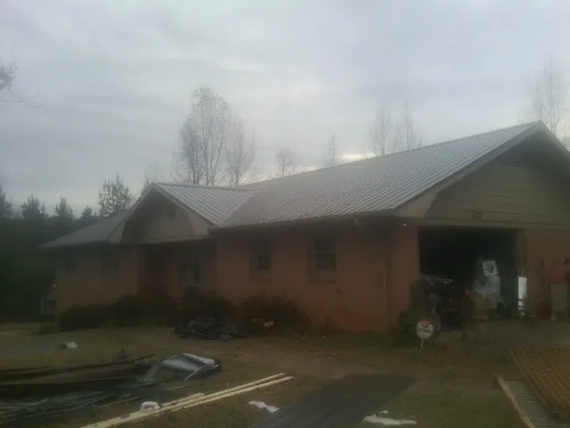 Gray metal roof on a stucco house with an attached garage in Waupaca