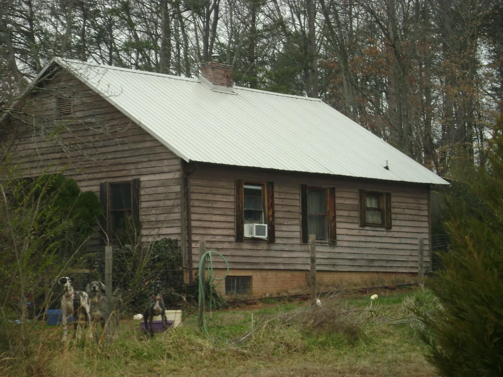 White metal roof on an old wood sided farmhouse, from a Metal Roof Installation job in Waupaca